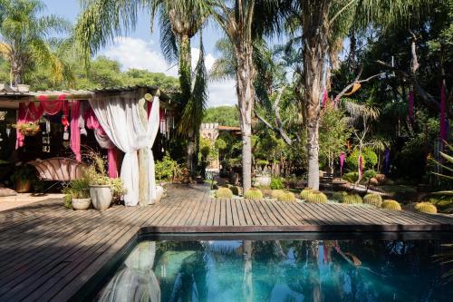 哈特比斯普特The Art Guesthouse的一个带游泳池和棕榈树的婚礼场地