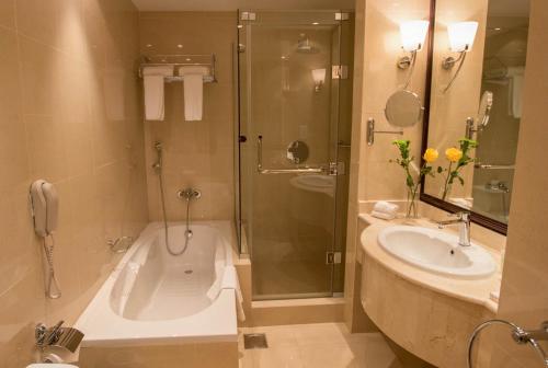 多哈雷托尤酒店的带浴缸、水槽和淋浴的浴室