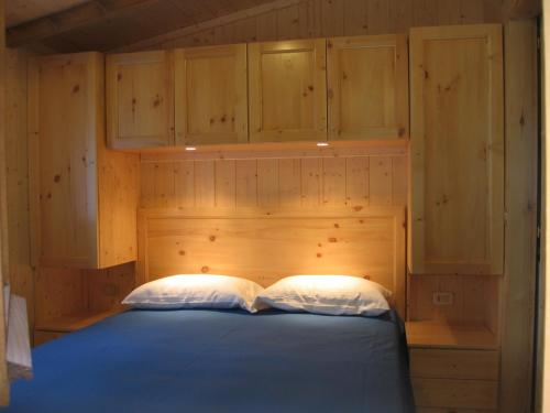 恩特拉奎Campeggio Valle Gesso的一间卧室配有一张蓝色的床和木制橱柜