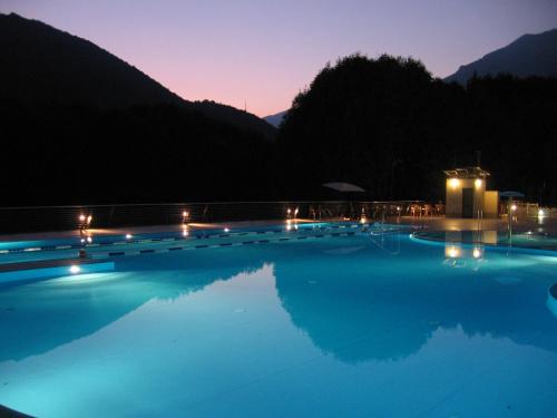恩特拉奎Campeggio Valle Gesso的夜间游泳池,灯光照亮