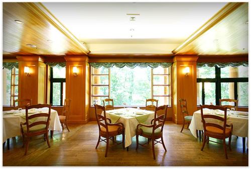 日光中禅寺金谷酒店的用餐室设有桌椅和窗户。