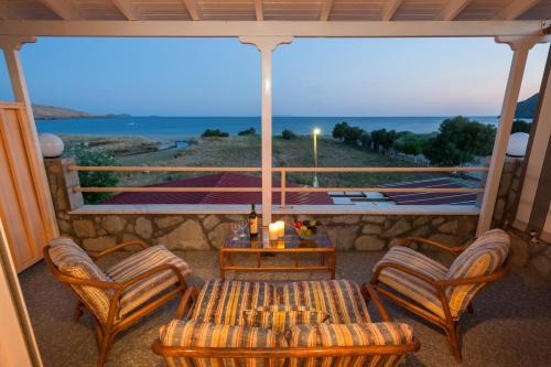 孔蒂亚斯Evgatis Hotel的一个带桌椅的海景门廊