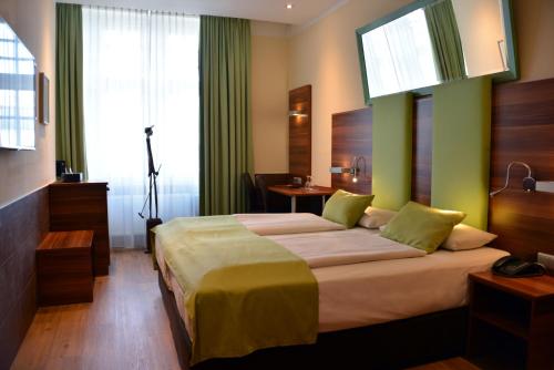 慕尼黑慕尼黑艺术酒店的一间卧室设有一张带绿色墙壁的大床