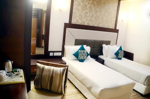 瓦拉纳西兰德马克酒店的酒店客房设有两张床和一张桌子。