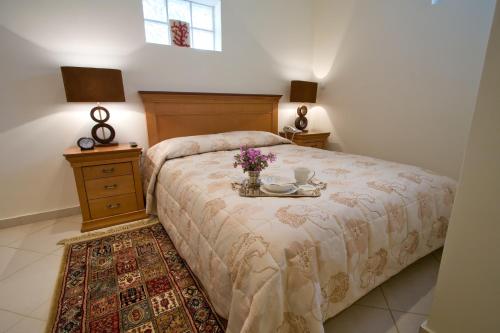 安德罗斯Andria Suites的一间卧室配有一张带鲜花桌的床