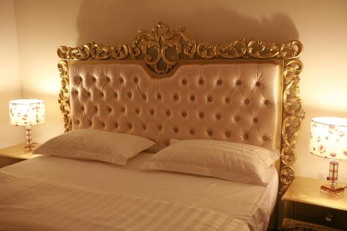 朱巴朱巴皇冠酒店 的一张带金色床头板和两盏灯的床