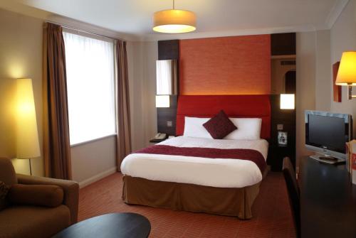 斯旺西飞龙旅馆的酒店客房,配有床和电视