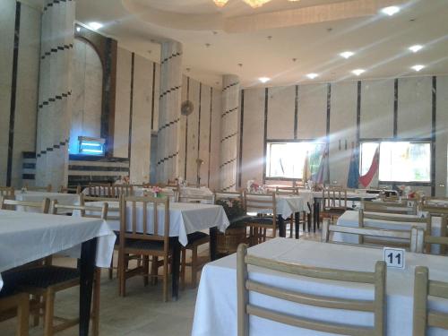 法耶兹Fanara Apartments Armed Forces的餐厅配有桌椅和白色桌布