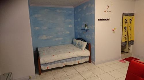 五结五结吾家民宿的一间卧室设有蓝色的墙壁,里面设有一张床