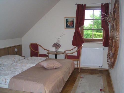 济维科夫斯科波德拉迪Apartment 53 Zvíkovské Podhradí的一间卧室配有一张床、一张桌子和一个窗户。