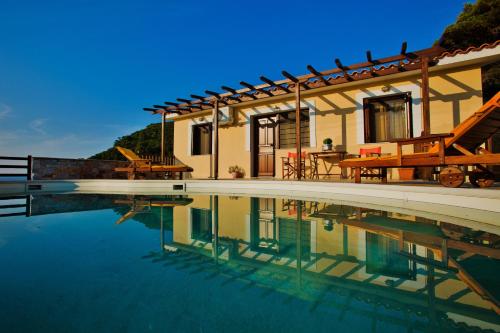 斯科派洛斯Porto Skopelos Villas的一座房子前面设有游泳池