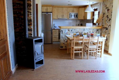 BielCasa Rural Las Lezas的厨房配有桌椅和冰箱。