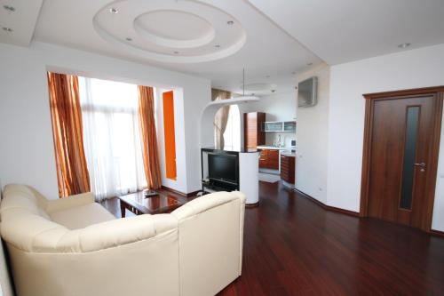 基辅基辅中心纯真家园公寓的客厅配有白色沙发和电视
