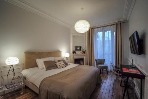 巴黎Relais12bis Bed & Breakfast By Eiffel Tower的一间卧室配有一张床、一张书桌和一台电视