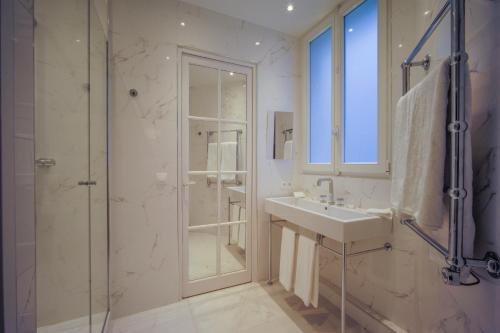 巴黎Relais12bis Bed & Breakfast By Eiffel Tower的白色的浴室设有水槽和淋浴。