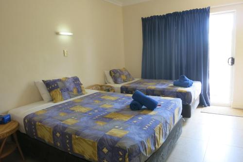 飞鱼湾VQ3山林小屋的一间卧室配有两张带蓝色枕头的床。