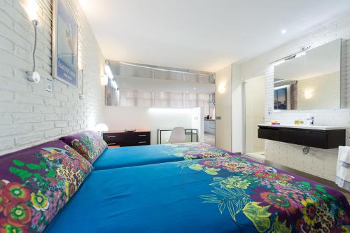 大加那利岛拉斯帕尔马斯Suites Garden Loft Dalí的配有浴室的客房内一张大蓝色的床