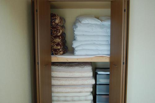 白马村Chalet 別邸しろうま的装满折叠毛巾和一叠毛巾的衣柜