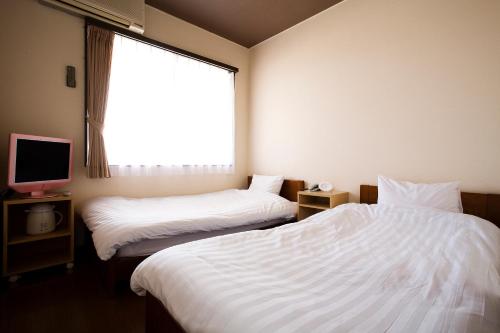 洲本市海月港酒店的酒店客房设有两张床和窗户。