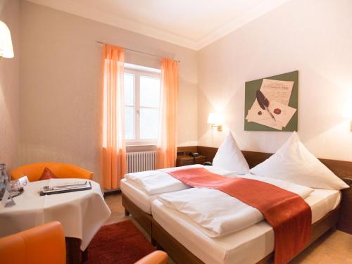 旧天鹅堡米勒酒店的一间卧室配有一张床、一张桌子和一个窗户。