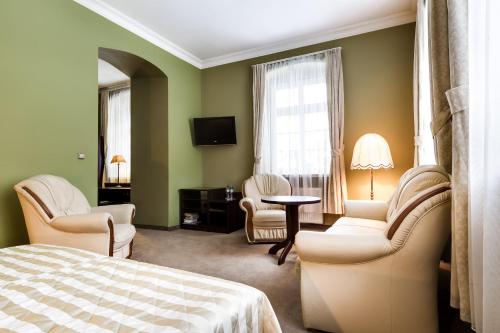 卡尔帕奇Pałac Spiż koło Karpacza的一间卧室配有一张床铺和椅子以及一台电视。