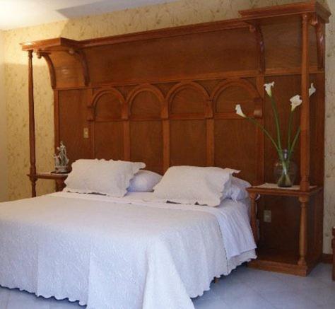 瓦斯卡坎波精髓精品酒店的一张带木制床头板和花瓶的床