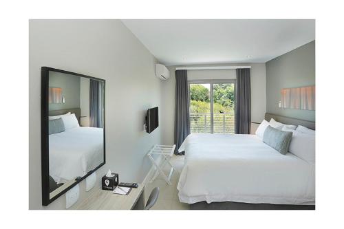 约翰内斯堡巴斯卡皮特尔公寓式酒店的酒店客房,设有两张床和镜子
