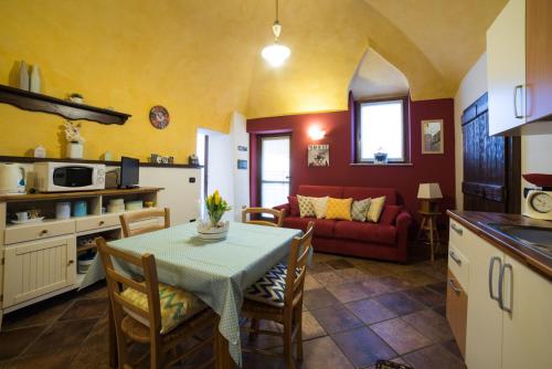 阿罗纳Casa Corte Alla Rocca的厨房以及带桌子和沙发的客厅。