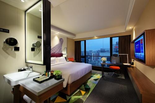 广州广州珠江新城希尔顿欢朋酒店的一间卧室配有一张床、一个水槽和一张书桌