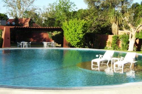 查克拉斯德科里亚罗伯斯德贝萨烈酒店的院子里带白色椅子的游泳池