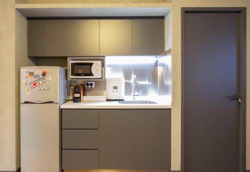 香港香港卓轩旅舍的小厨房配有冰箱和微波炉。