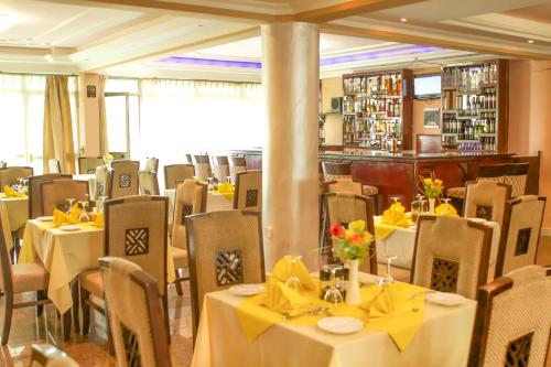 贡德尔AG Hotel Gondar的用餐室配有桌椅和黄色弓