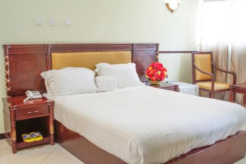 贡德尔AG Hotel Gondar的一间卧室配有一张大床和木制床头板