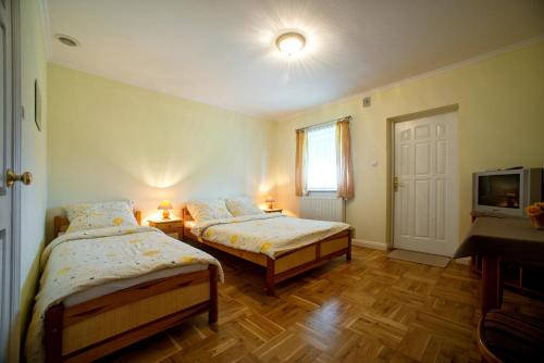 波拉齐克Pensjonat Eskapada的一间卧室设有两张床、一台电视和一扇窗户。