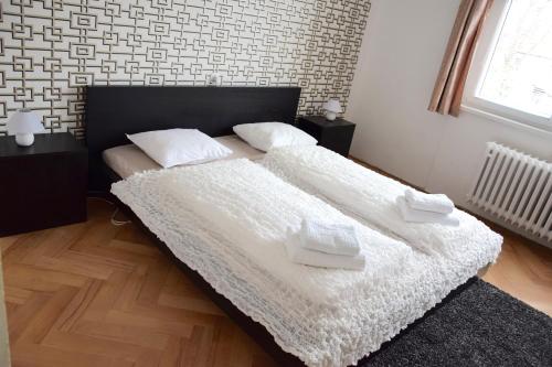 布拉格布拉格古典之家6号度假屋的一间卧室设有两张带白色床单的床和窗户。