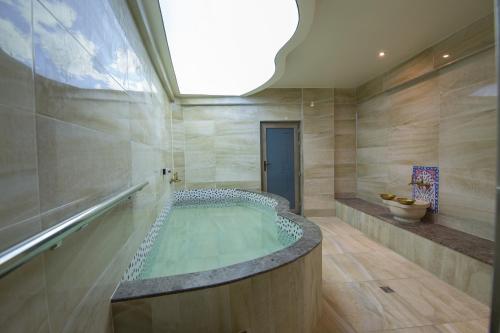 伯萨Ruba Palace Thermal Hotel的一间大浴室,内设热水浴缸