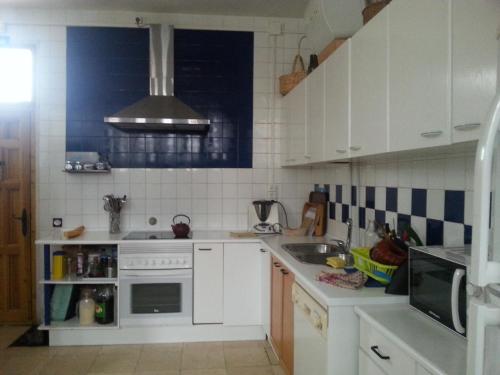 Arcones埃尔富希奥德尔德拉贡旅舍的白色的厨房设有水槽和炉灶。