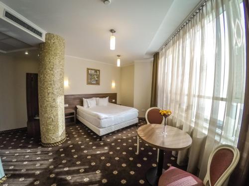 阿尔巴尤利亚赫耳墨斯酒店的酒店客房设有一张床和一个大窗户
