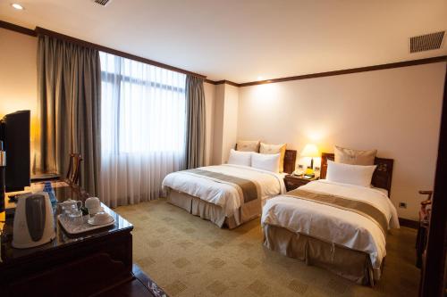 台北富园国际商务饭店的酒店客房设有两张床和电视。