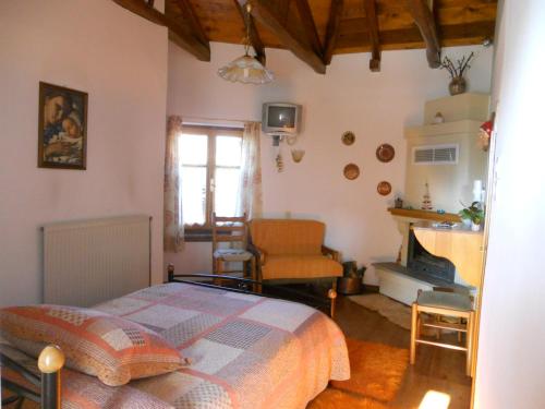 阿伊埃斯拉伦蒂欧斯Sarafis Guesthouse的一间卧室配有一张床、一把椅子和一个壁炉