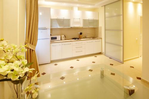 基希讷乌Ultra Central Park Apartments的厨房配有白色橱柜和白色冰箱。