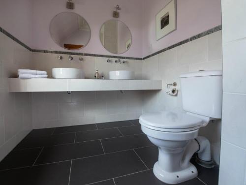 斯托诺韦The Park Guest House, Stornoway的浴室设有白色卫生间和两面镜子。