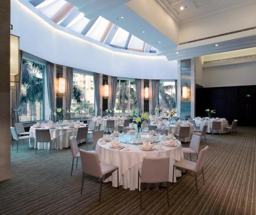 Shunde顺德新世界酒店(6月盛夏礼遇）的宴会厅配有白色的桌椅和窗户