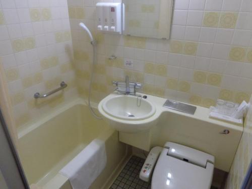 八户市八户威阿雷二号酒店的浴室配有盥洗盆、卫生间和浴缸。