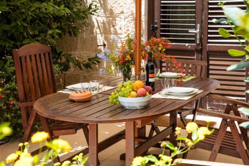 法维尼亚纳伊尔博尔戈德尔普林奇皮诺酒店的一张木桌,上面放着一碗水果和一瓶葡萄酒