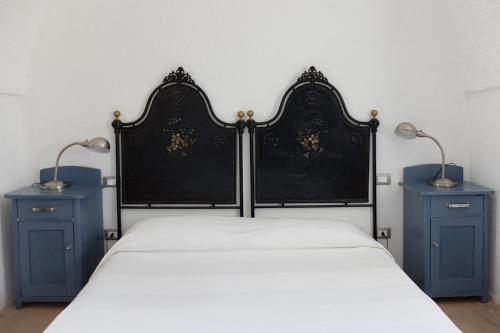 奥斯图尼Masseria Palombara Grande的一间卧室,配有一张带两个蓝色床头柜的床
