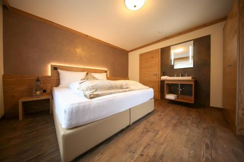 图克斯Chalet Alpinhome的卧室配有一张白色大床,铺有木地板