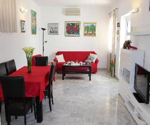 特斯特诺Holiday Home Platanus的客厅配有红色桌子和红色沙发