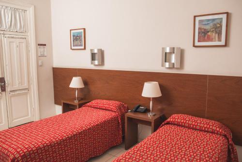 科尔多瓦阿根廷科尔多瓦维多利亚格兰酒店的两张位于酒店客房的床铺,配有红色床单