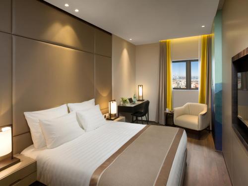 海法海法金冠酒店的酒店客房设有一张大床和一张书桌。